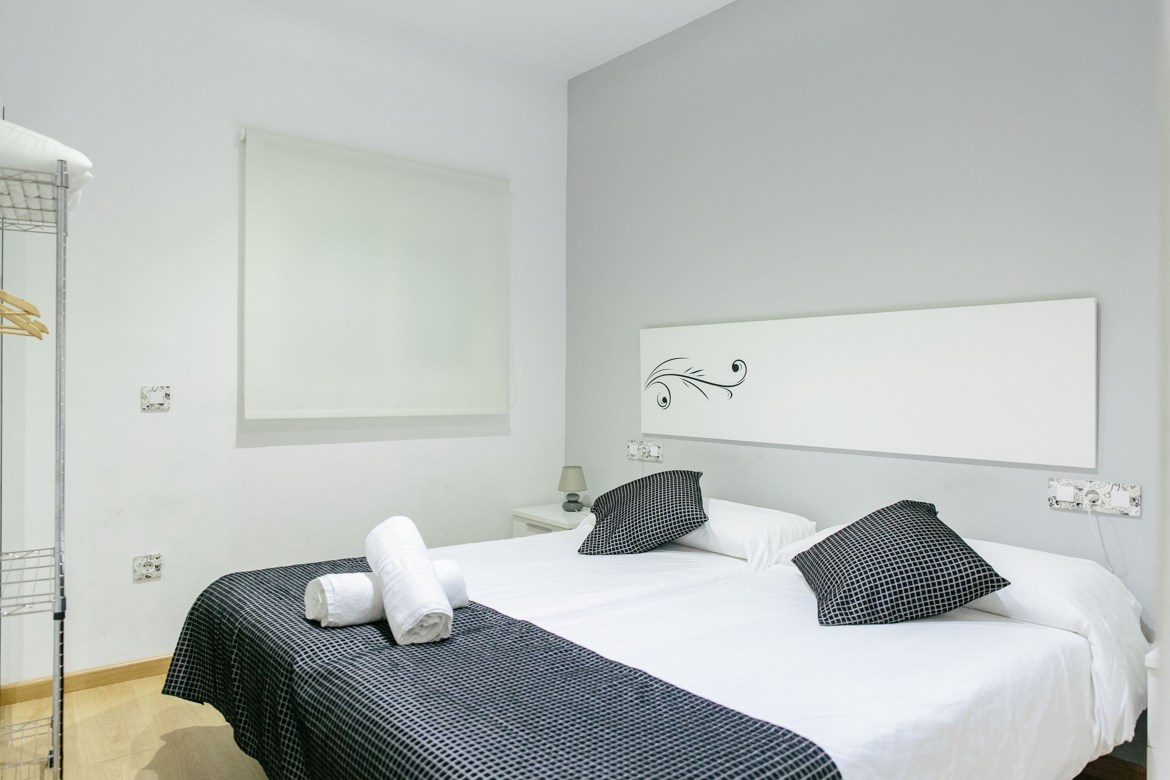 Een hotelkamer met een bed, een kunstwerk aan de wand en een handdoek op het bed.