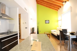 Uma cozinha moderna com bancada de granito, coifa de aço inoxidável e área de jantar com mesa e cadeiras.