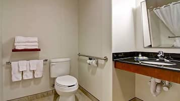 A bathroom with a toilet, a sink, a mirror, and a towel rack.