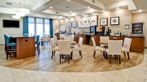 Una cocina moderna con barra, sillas de comedor y un ventanal grande.