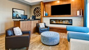 Una sala de estar moderna con chimenea, televisor de pantalla plana y asientos cómodos.