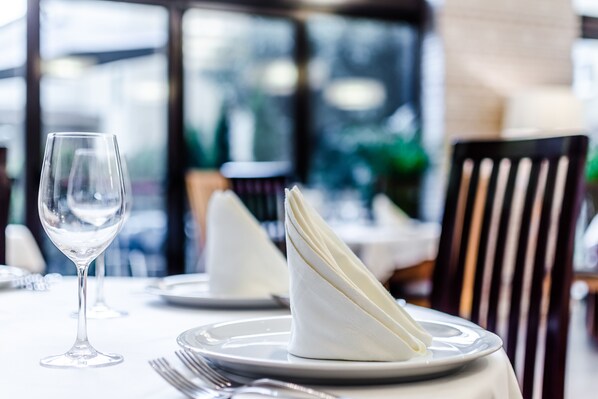 A dining table set with a white napkin, a wine glass, and silverware. - Hospedería Pax (León)