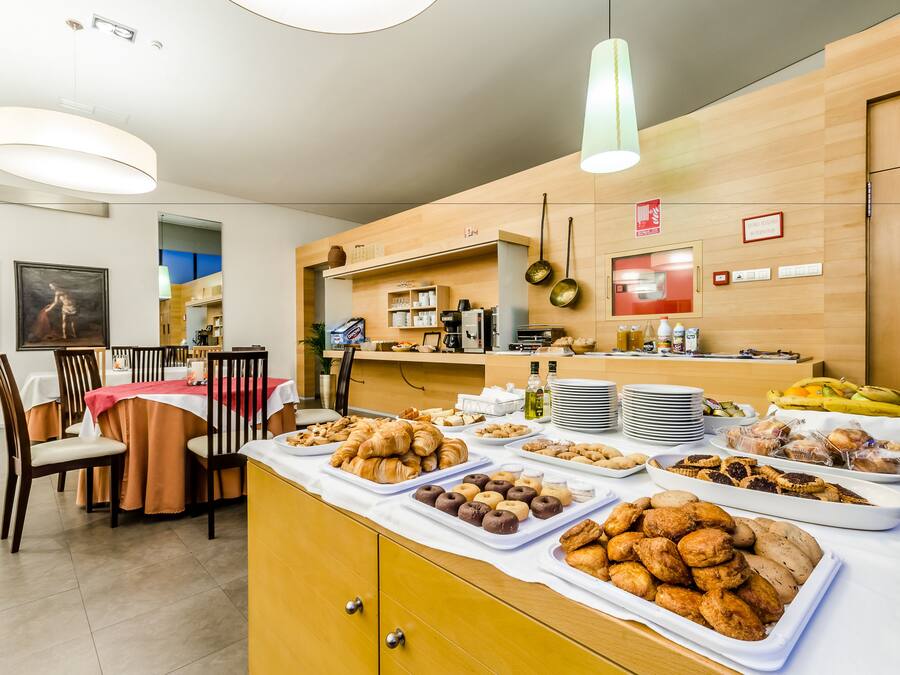 Un bufé de desayuno con diversos pasteles y productos de panadería.