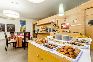 A breakfast buffet with various pastries and baked goods. - Hospedería Pax (León)