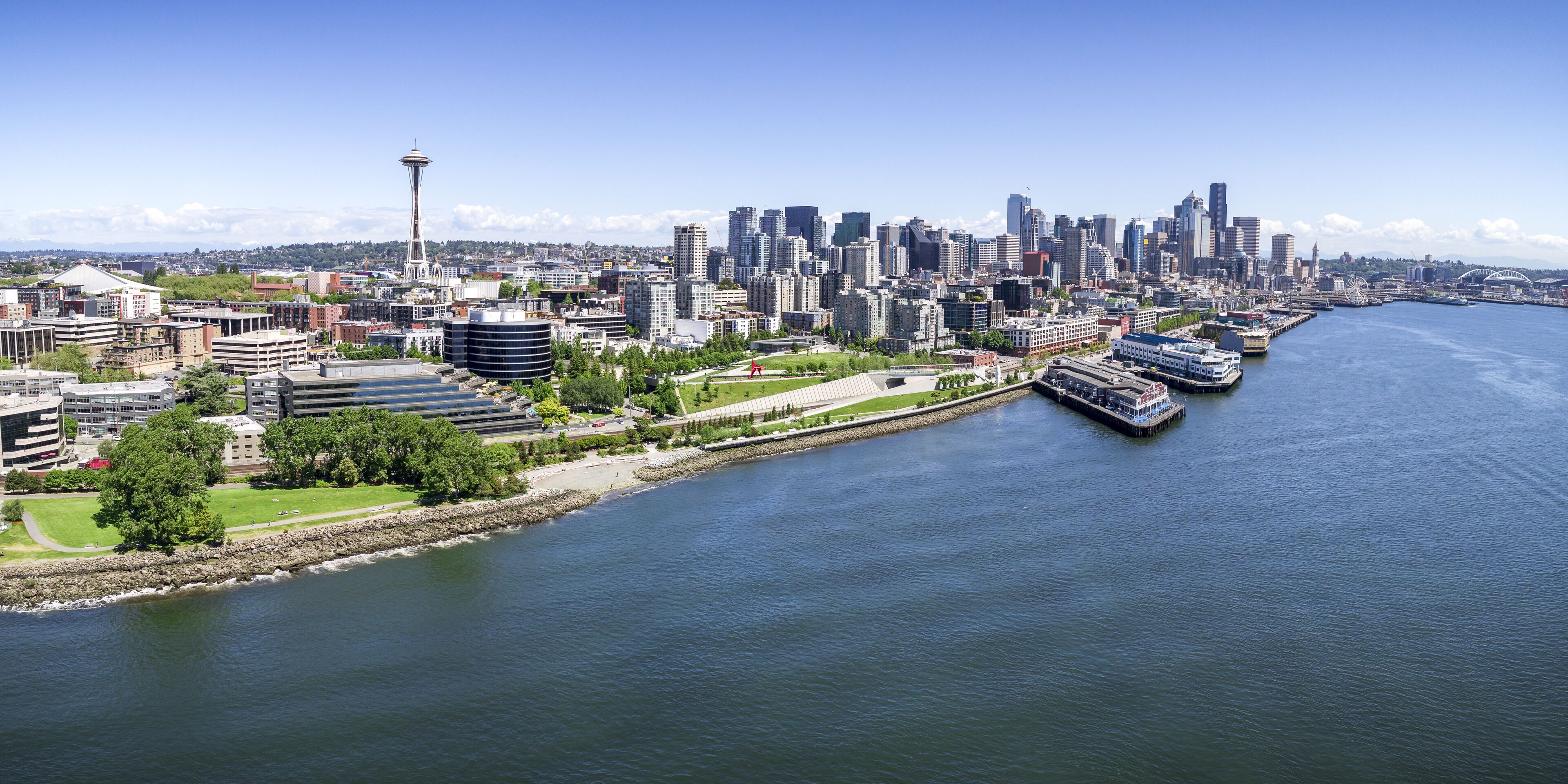 A cityscape with a prominent tower, a river, and a waterfront area with boats.