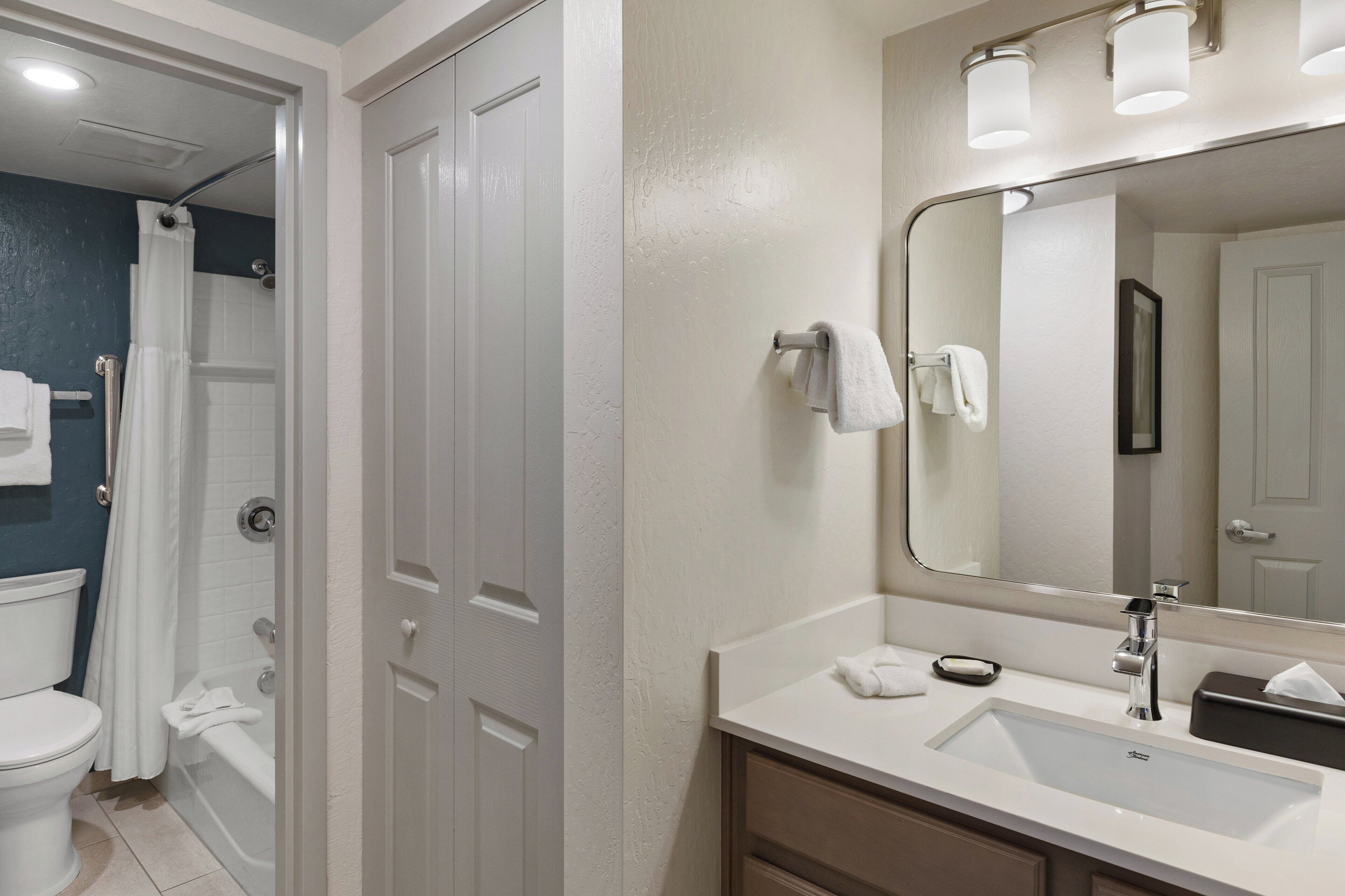 A bathroom with a white sink, mirror, and shower curtain.