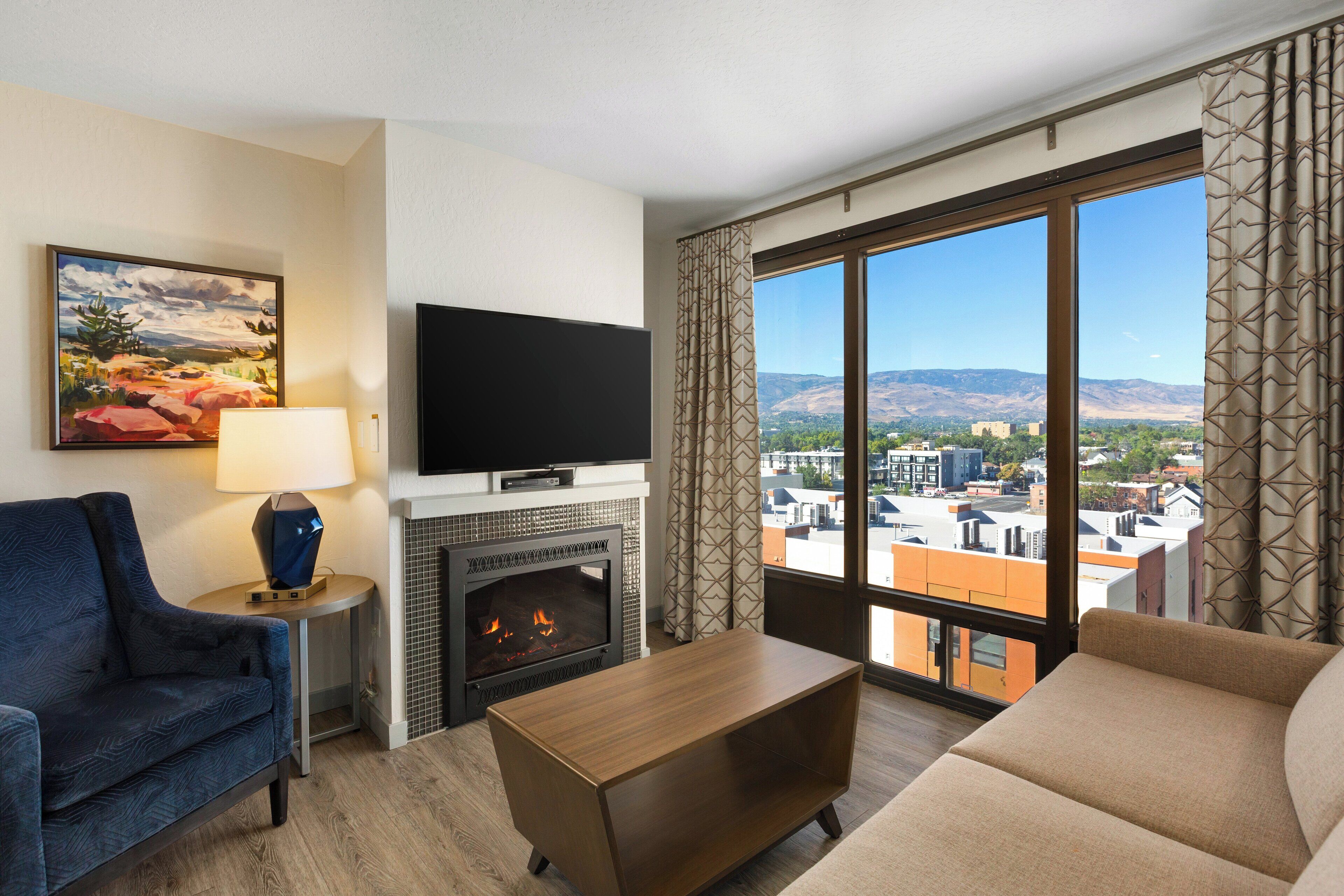 A modern living room with a fireplace, a flat-screen TV, and a sofa.