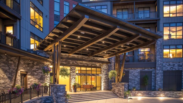 A hotel entrance with a covered patio, stone facade, and a staircase leading to the entrance. - Club Wyndham Resort at Avon (Avon)