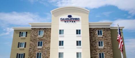 A hotel with a stone facade, multiple windows, and an American flag.