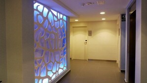 Un pasillo con un separador decorativo que presenta un diseño geométrico.