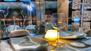Mesa lista para comer con vista a la ciudad iluminada de noche.