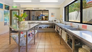Una cocina moderna con electrodomésticos de acero inoxidable, un ventanal grande y piso de baldosas.