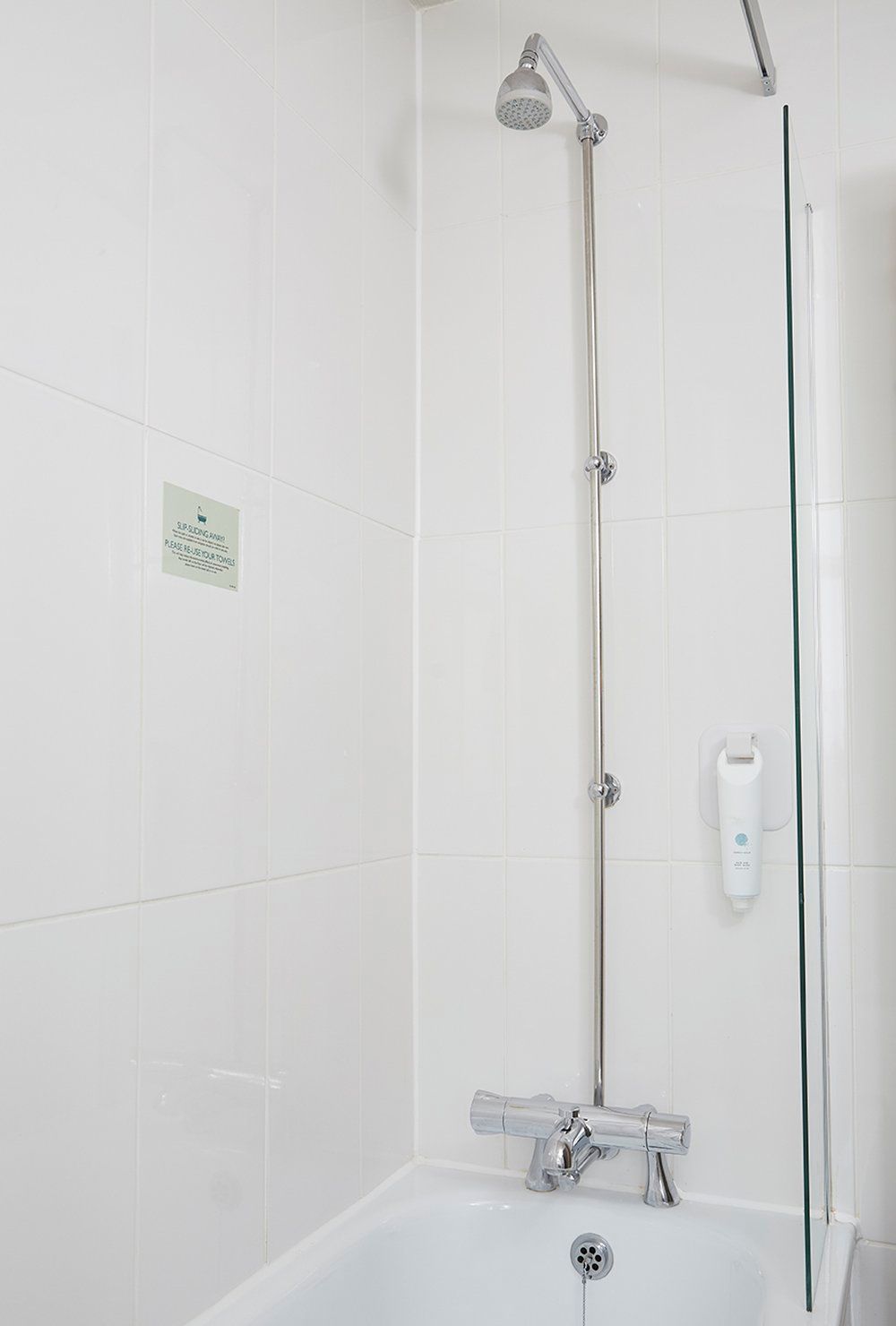 A modern bathroom with a shower, a toilet, and a hand dryer.