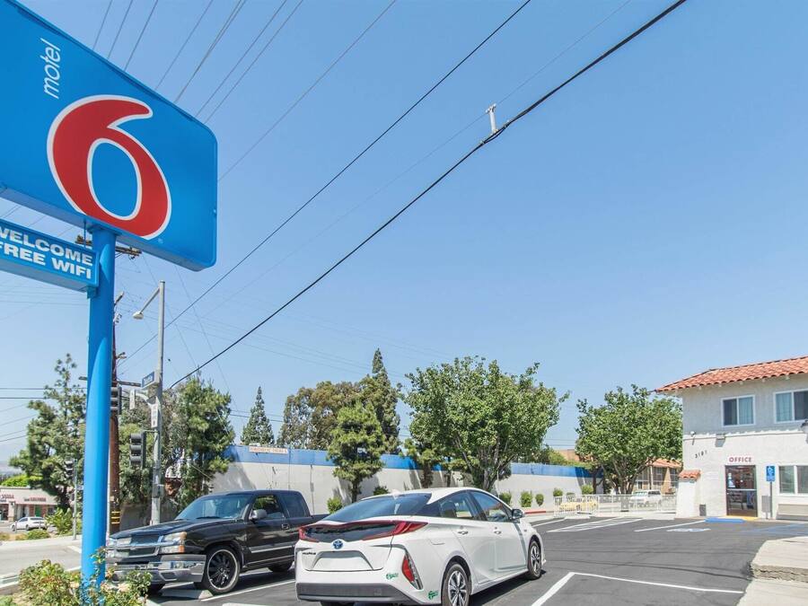 A motel sign with a large number '6' and a 'Welcome Free Wifi' sign.