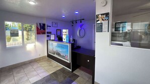 A reception area with a counter, framed certificates, and a large number '6' sign. - Motel 6 Orange, CA - Anaheim (Orange)