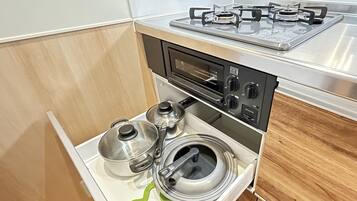 A compact kitchen with a gas stove, oven, and a built-in microwave.