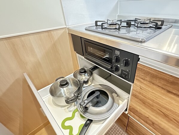 Una cocina compacta con estufa a gas, horno y microondas integrado.