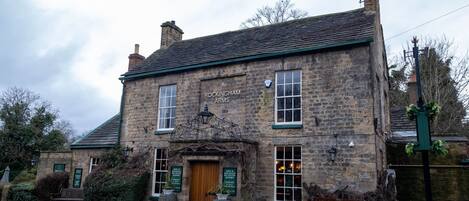 A stone building with a sign reading "ROCKINGHAM ARMS."