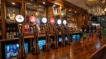 A bar with multiple beer taps and a variety of liquor bottles.