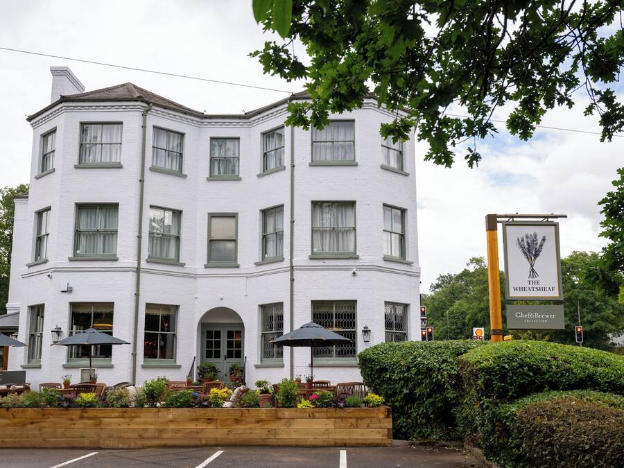A white building with multiple windows and a signboard.