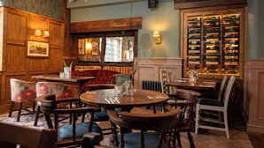 A cozy dining area with wooden furniture, a wine rack, and a fireplace.