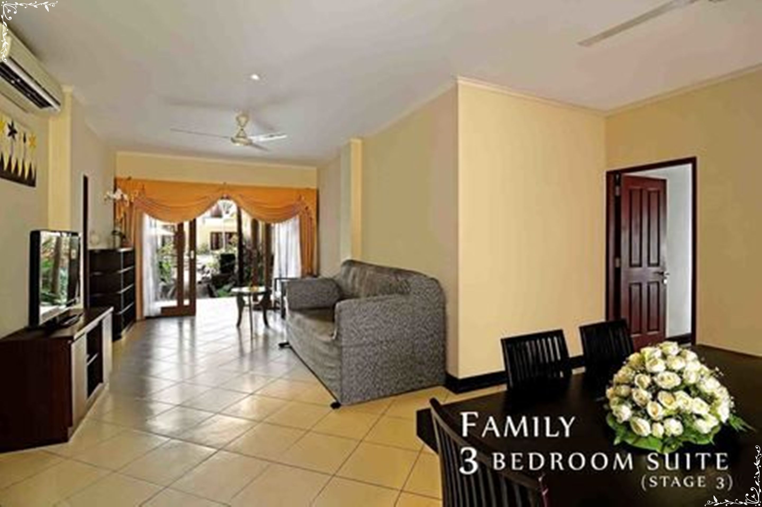 A family 3-bedroom suite with a dining area, a sofa, and a TV.