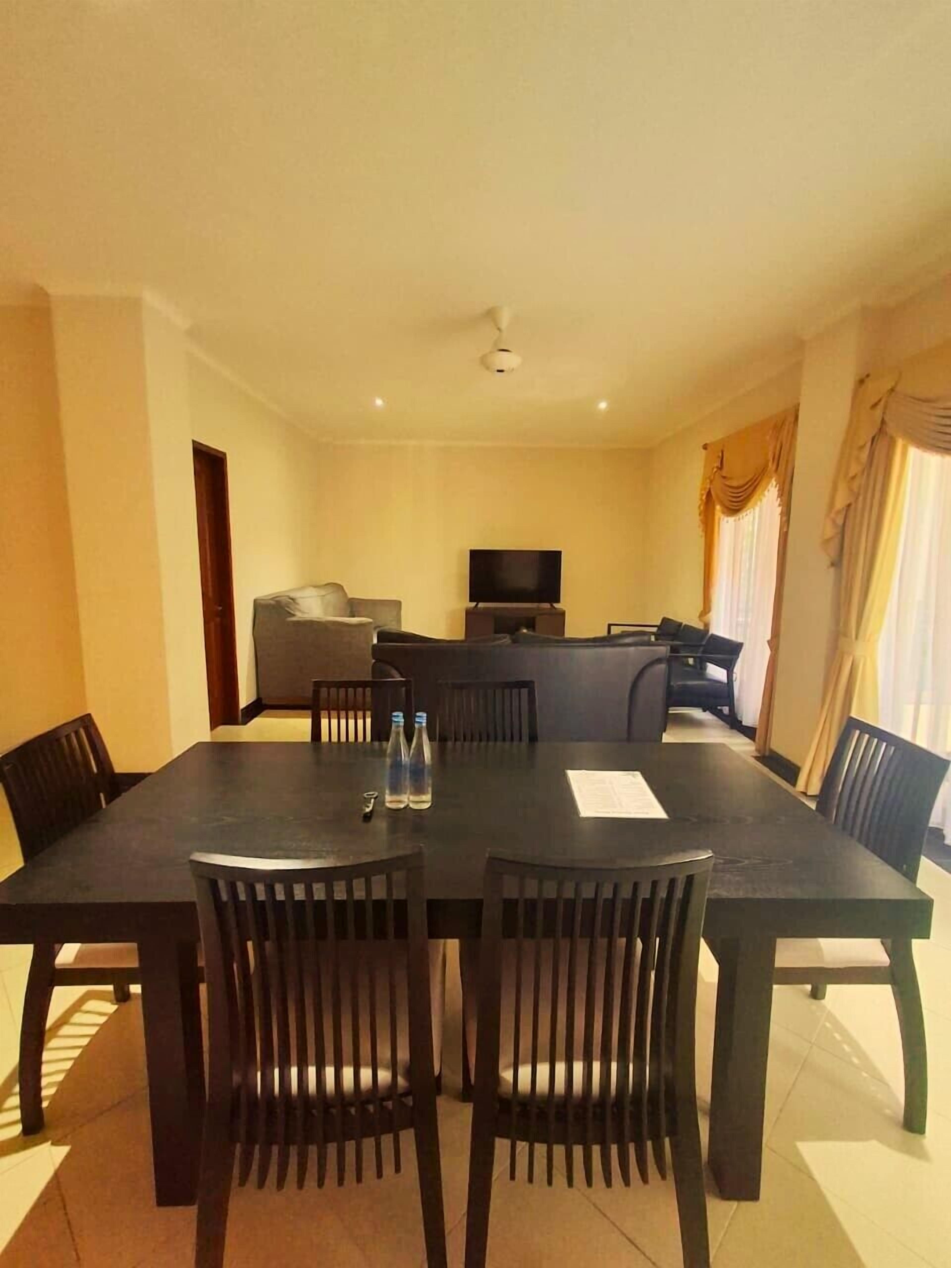 Un comedor con una mesa, sillas, un televisor y un sofá.