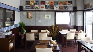 A restaurant interior with tables, chairs, a counter, and wall decorations. - Hibis Resort (Nakijin)