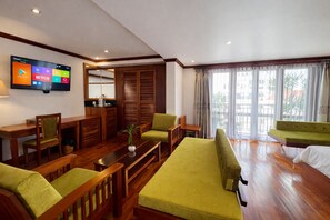 Una sala de estar moderna con muebles de madera, un televisor de pantalla plana y vistas amplias por las ventanas.