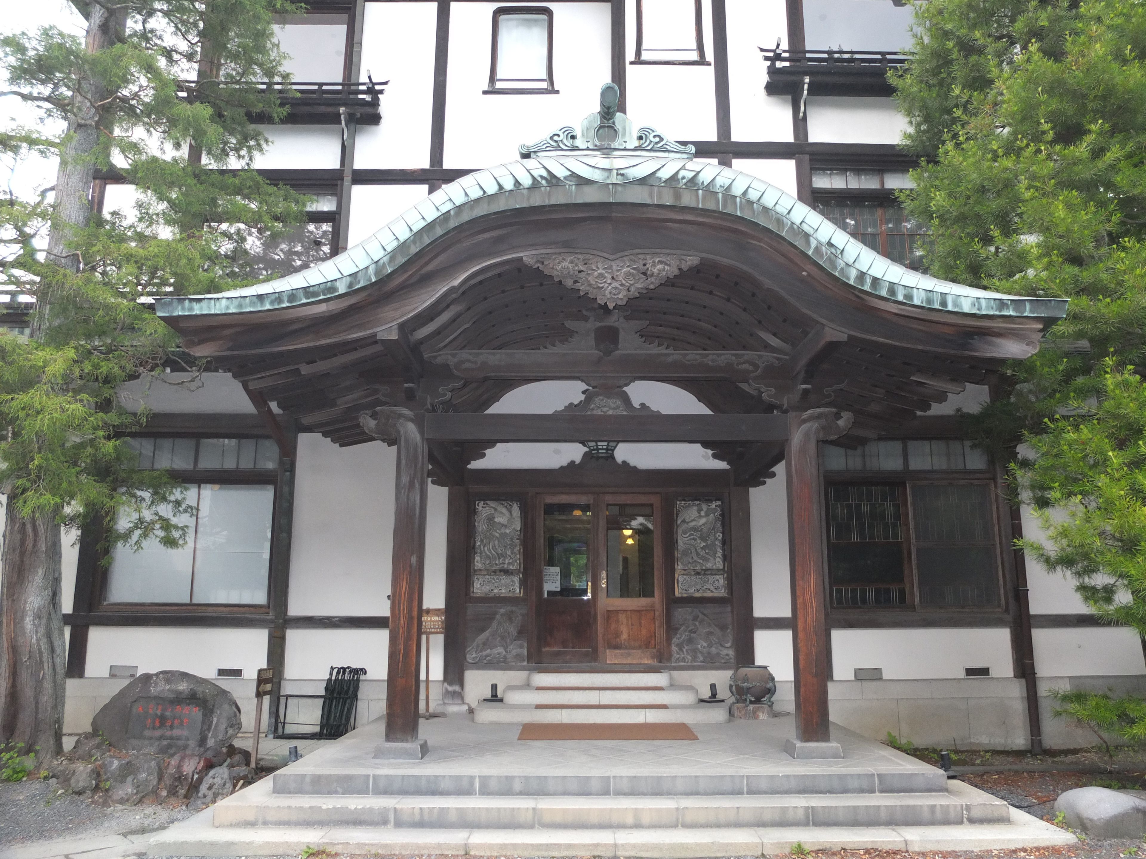 A traditional Japanese building with a wooden entrance and a tiled roof.