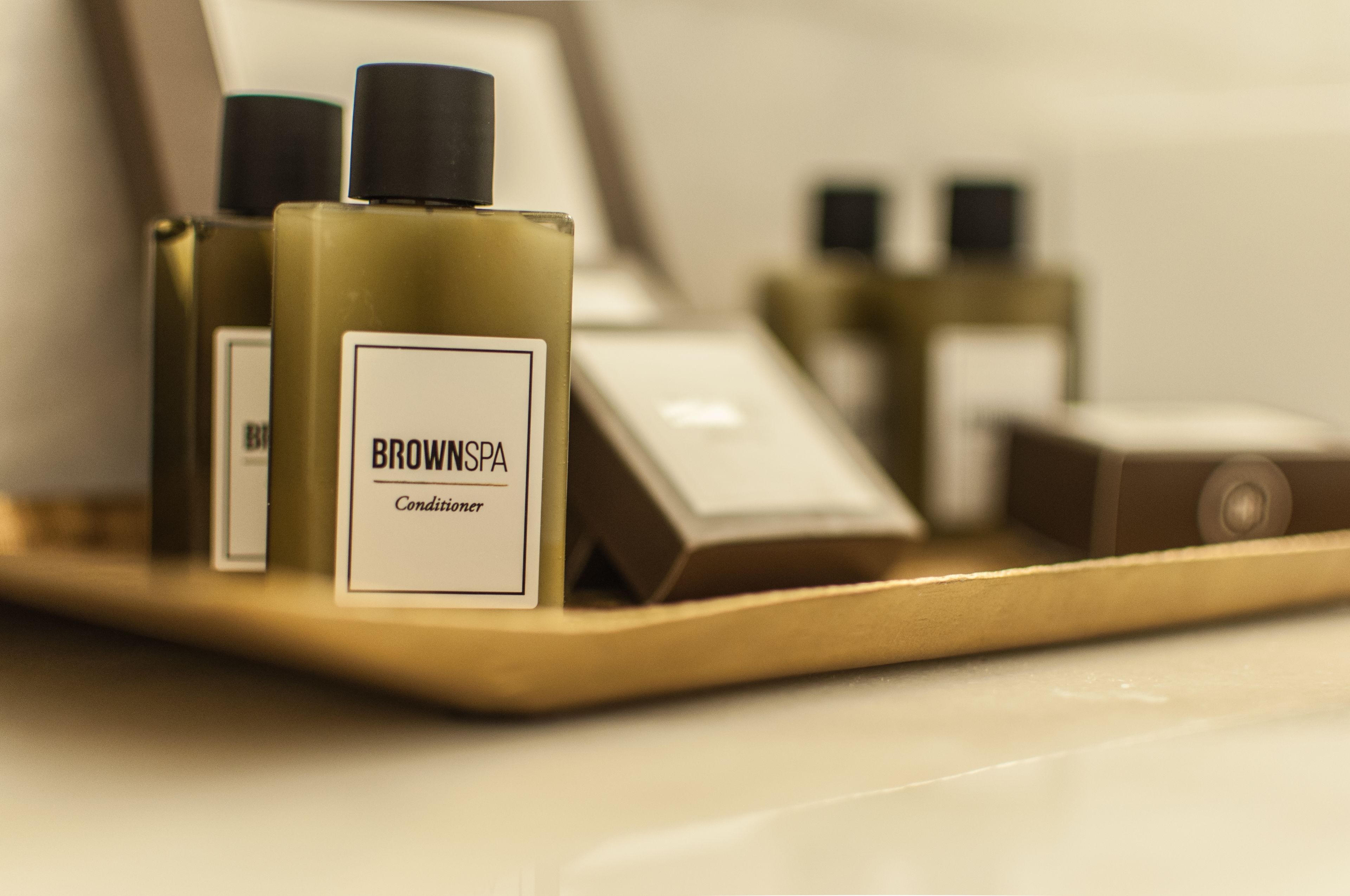 Un plateau contenant des bouteilles étiquetées « après-shampoing BROWNSPA » et d’autres articles de toilette.