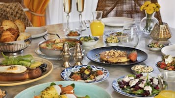 A dining table with various dishes, glasses, and a vase of flowers.