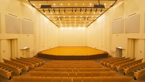 An auditorium with rows of seating, a stage, and a ceiling with lights. - Chao She Hotel (Kaohsiung)