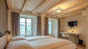 Une chambre avec deux lits, un bureau, une chaise et un téléviseur.