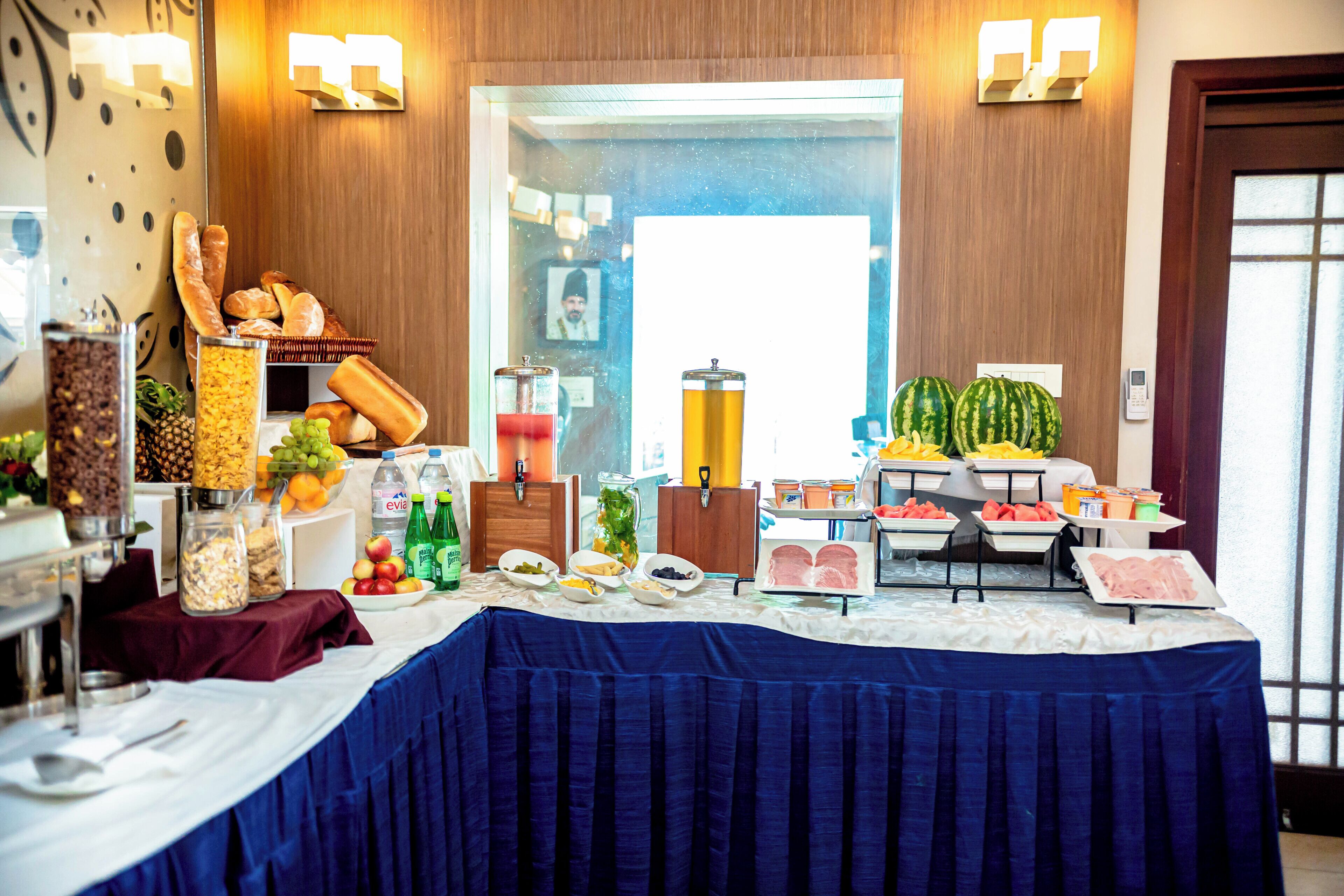 A buffet table with various food items and condiments.