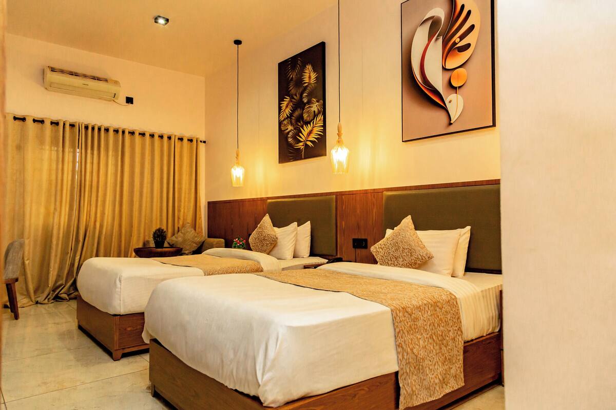 A hotel room with two beds, a wooden headboard, a wall-mounted air conditioner, and a decorative painting.