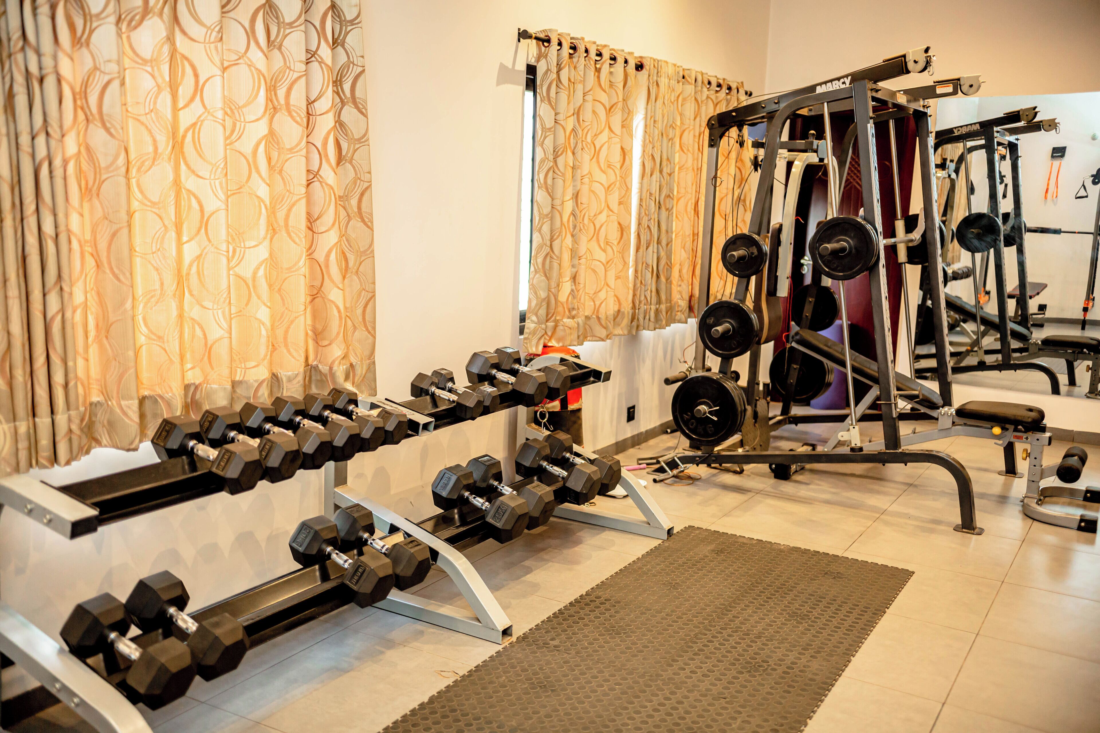 A gym with weightlifting equipment, including dumbbells and a squat rack.