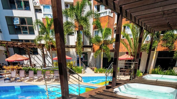 Un espace piscine sur le toit, avec des bains à remous et des chaises longues.