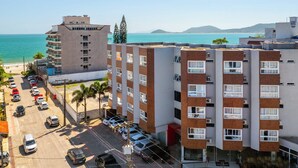 Un hôtel à plusieurs étages doté d’un parking et offrant une vue sur la plage et la mer.