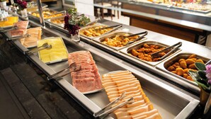 Un buffet proposant une variété de plats, notamment des viandes et des fromages coupés en tranches.