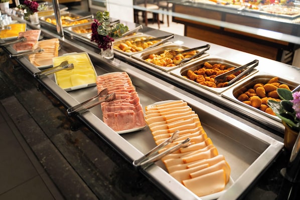 A buffet with various food items including sliced meats and cheeses. - Hotel Boulevard Beach Canasvieiras (Florianópolis)