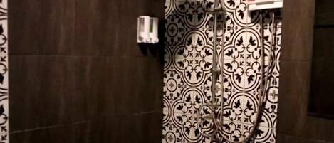 Une salle de bain avec une douche, des toilettes et un lavabo.