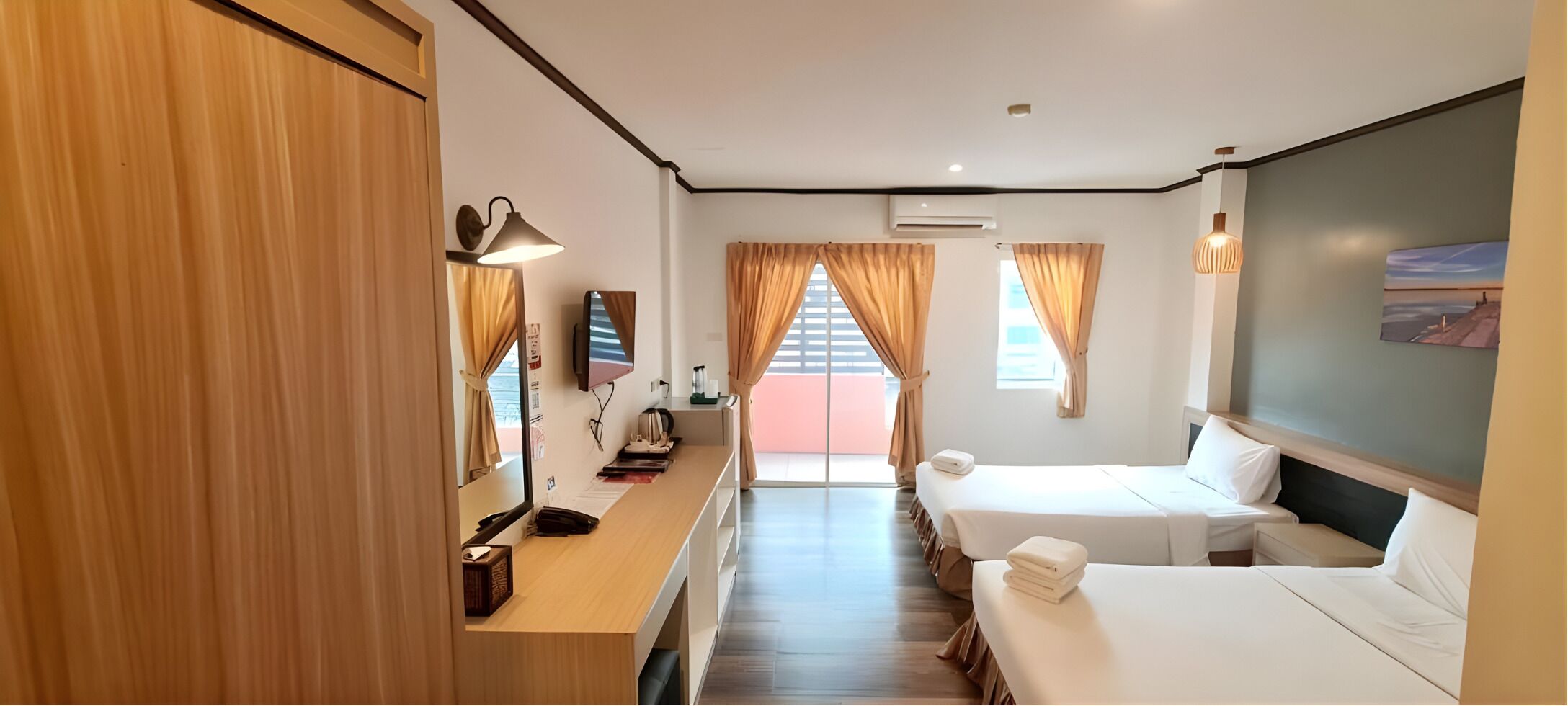 A hotel room with a bed, a desk, a chair, a TV, and a window with curtains.