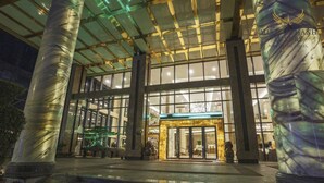 A modern hotel entrance with large glass doors, a well-lit interior, and prominent columns. - Muong Thanh Luxury Nha Trang Hotel (Nha Trang)