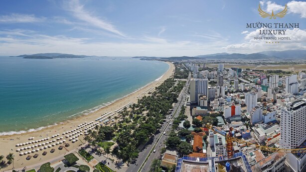 A coastal cityscape with a beach, urban buildings, and a clear sky. - Muong Thanh Luxury Nha Trang Hotel (Nha Trang)