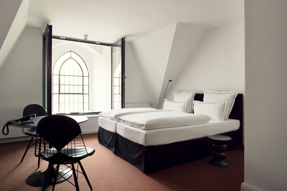 Ein modernes Schlafzimmer mit Bett, Schreibtisch und Stuhl.