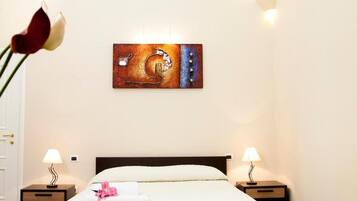 A hotel room with a bed, two bedside tables, a wall-mounted artwork, and a patterned floor.