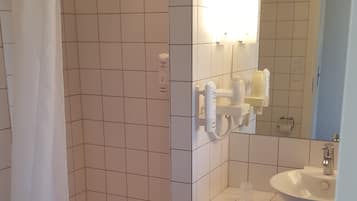 Un bany amb dutxa, vàter i rentapans.