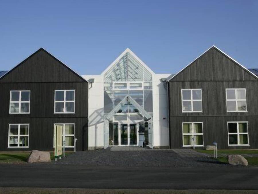 A row of three buildings with a central glass structure.