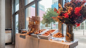 Una mesa de buffet con diversas opciones de pastelería y un jarrón decorativo.